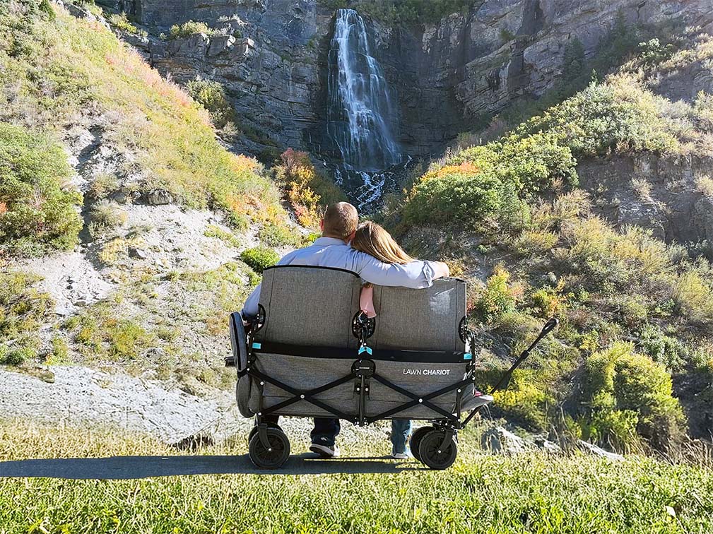 Couple sitting in Lawn Chariot watching a waterfall